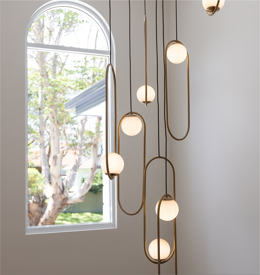 Gold 7-light staircase chandelier with cascading glass pendants for narrow stairwell lighting