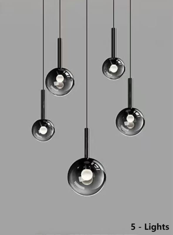 
These five gradient-colored glass pendant lights are custom-made for high-end residences.  The black, gradient-colored light spheres come in various sizes, making them suitable for smaller spaces such as above a dining table.