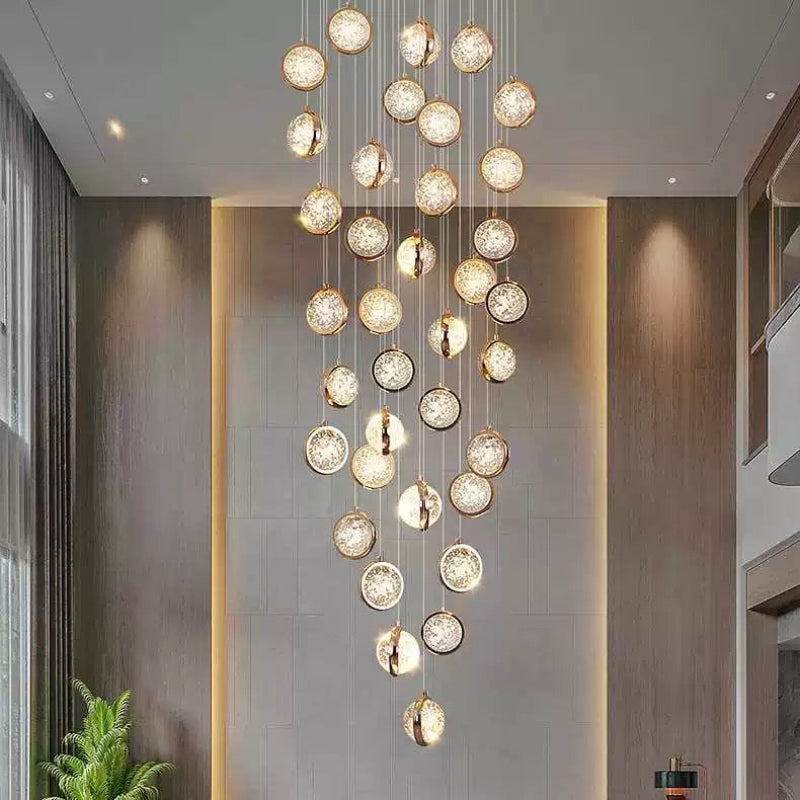 Gold bubble ball chandelier cascading down stairwell, spiral K9 crystal design for high ceiling foyer lighting