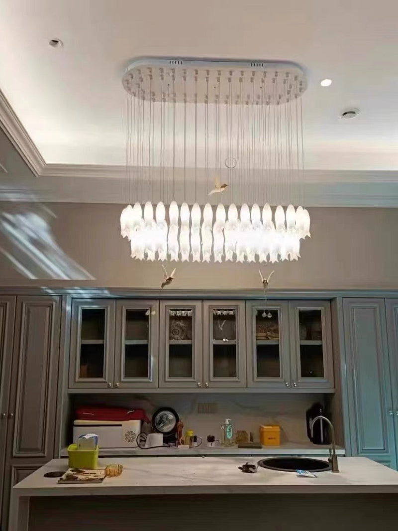 The kitchen island is adorned with exquisite ceramic plant pendants, decorated with handcrafted flowers and hummingbird motifs, adding beauty to the space.