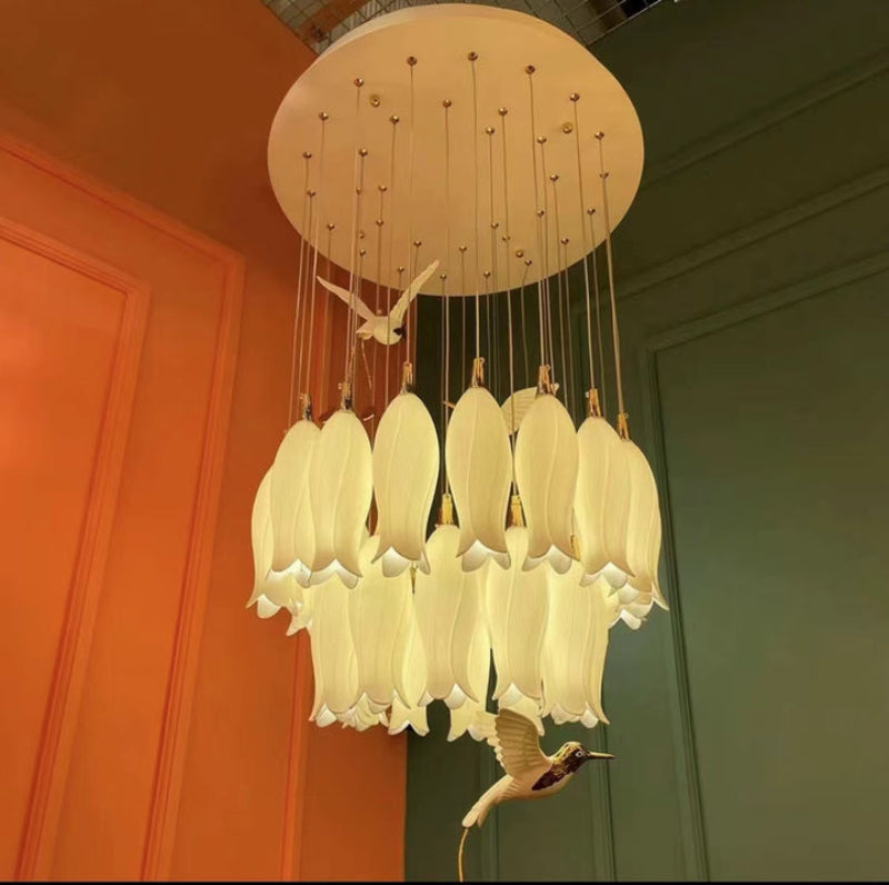 Minimalist ceramic petal pendant light with artistic hummingbird accents for modern stairwell foyer high ceiling