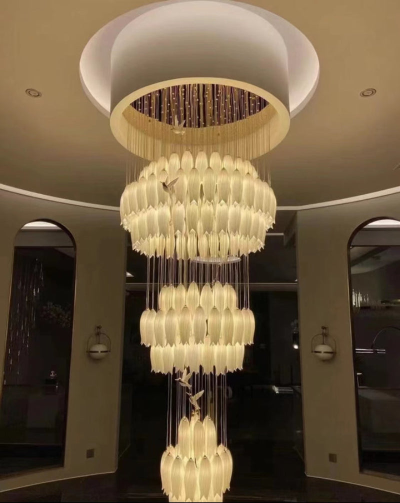 Grand ceramic flower chandelier featuring three-dimensional petals and hummingbird accents for luxury staircase foyer