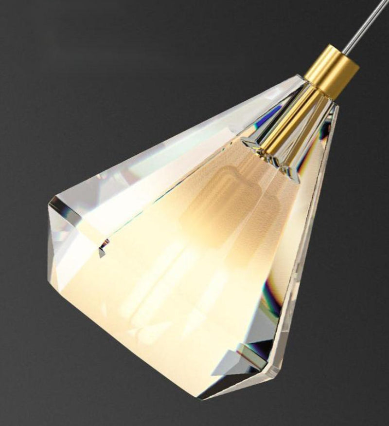Crystal pendant light with gold fixture on a black background