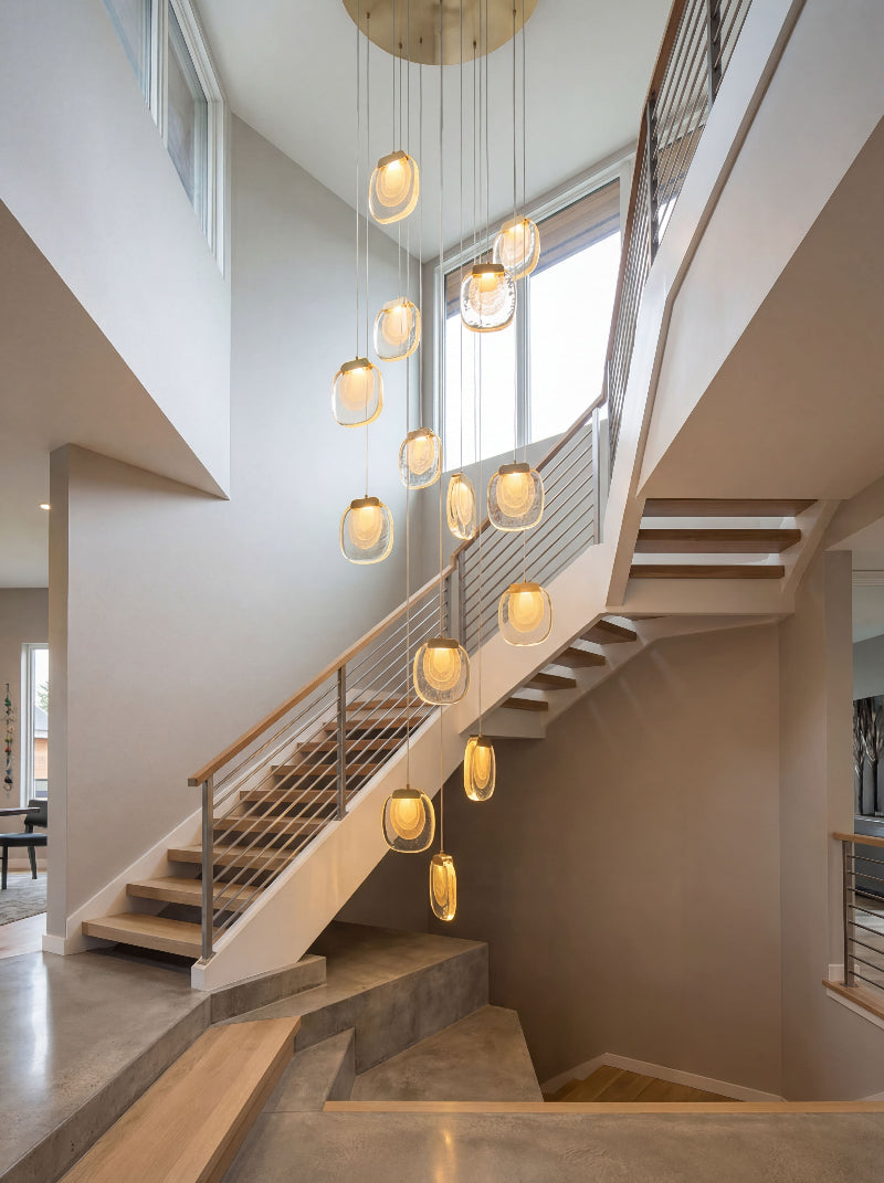 Contemporary golden cascade crystal pendant light with tiered waterfall design creating brilliant sparkle in modern foyer high ceiling