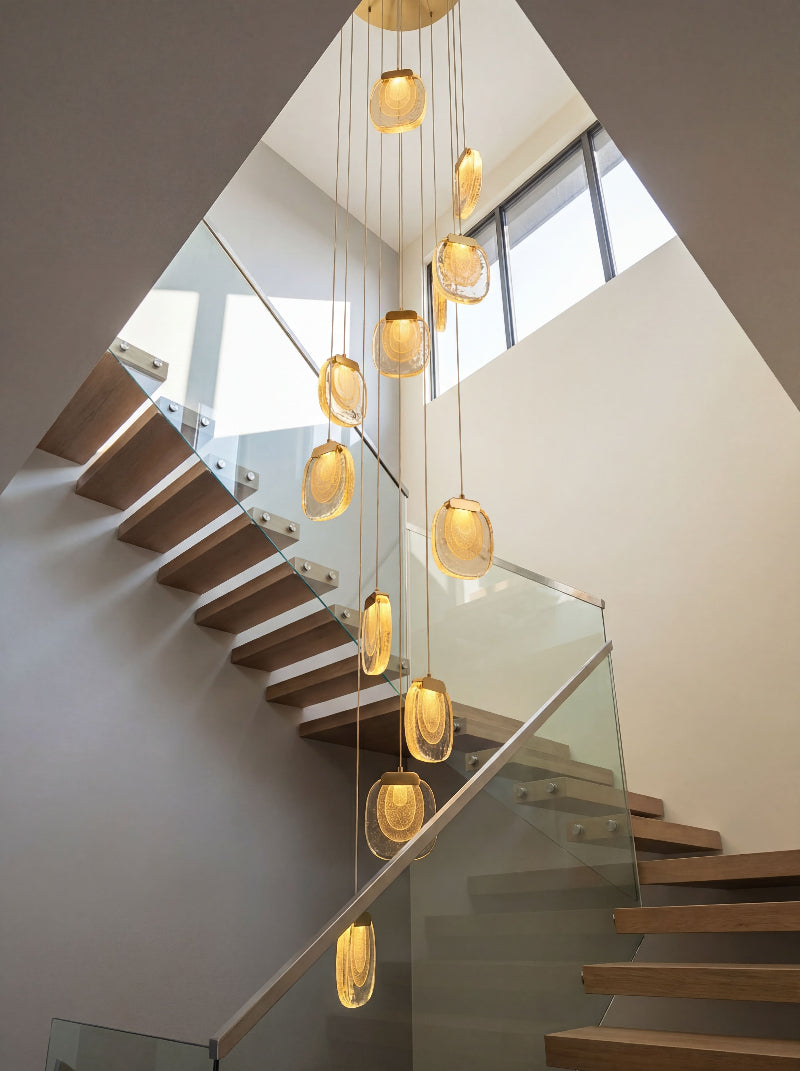 Elegant gold cascade chandelier with flowing crystal tiers creating luxurious waterfall effect for residential entryway staircase
