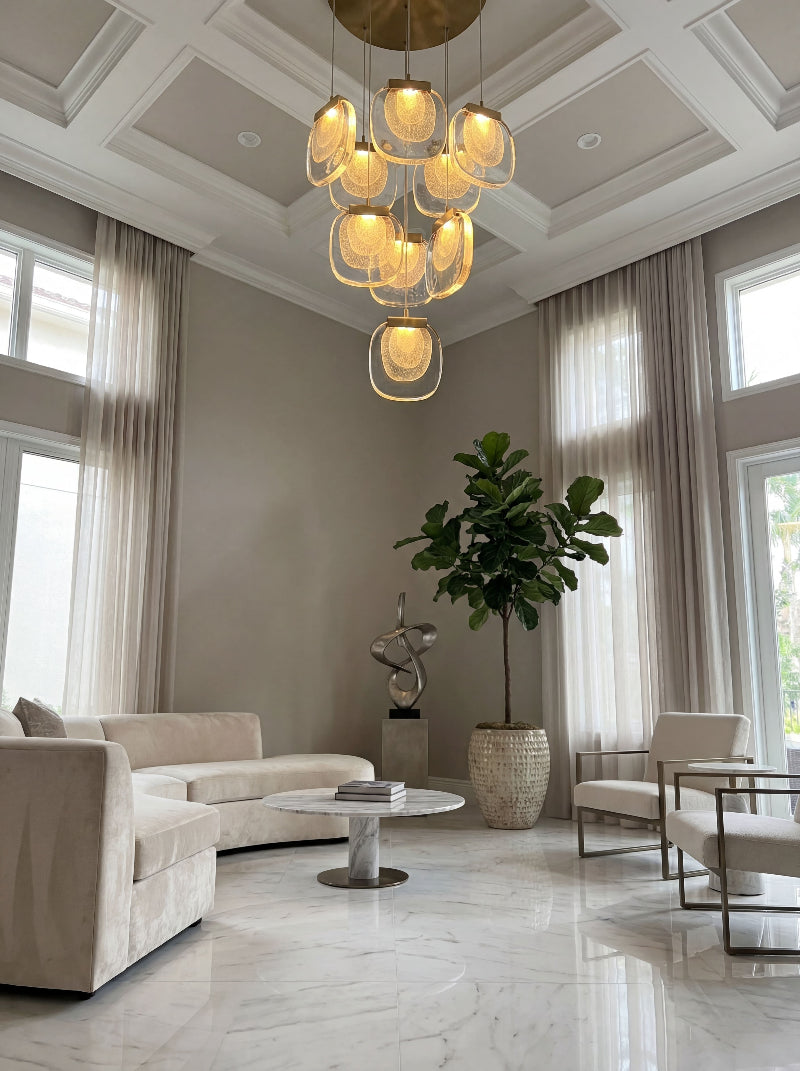 Modern golden cascade crystal pendant light with layered waterfall design illuminating contemporary living room high ceiling space