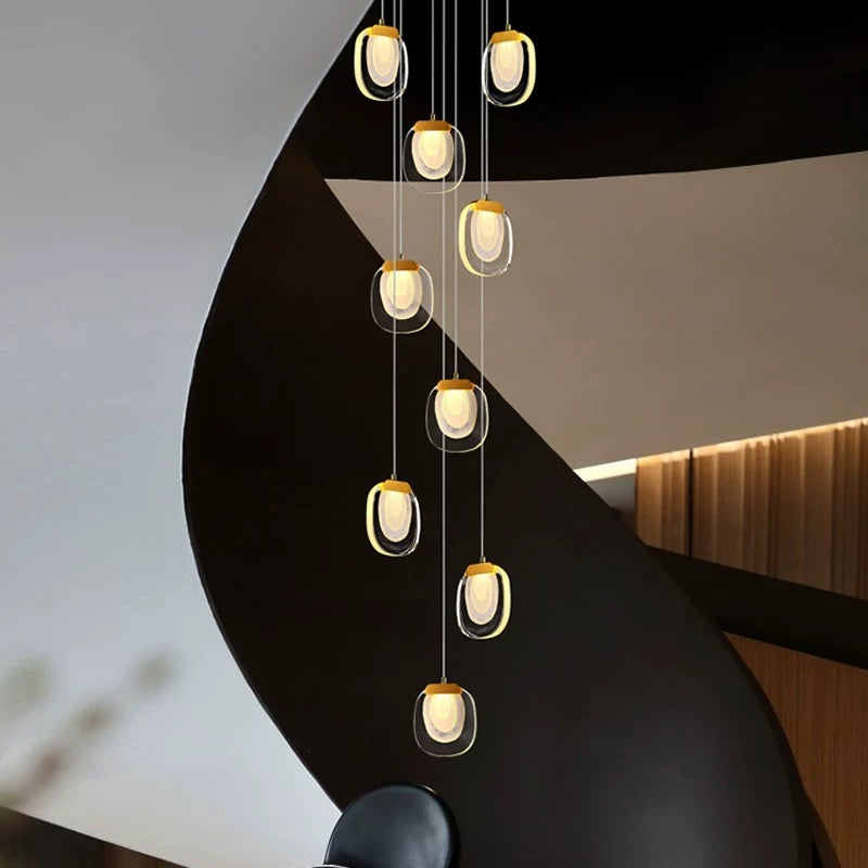 A round, gold-finished, cascading crystal chandelier with a modern, multi-layered design, suitable for entryways and spaces with high ceilings.