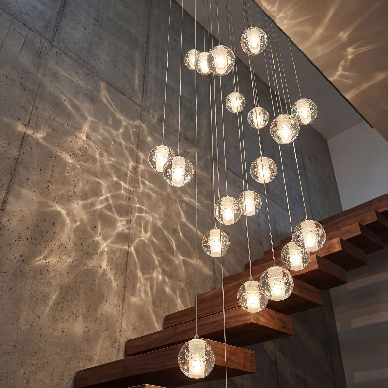 Elegant bubble crystal staircase chandelier with chrome finish and warm dimmable LED creating inviting glow in residential foyer entryway