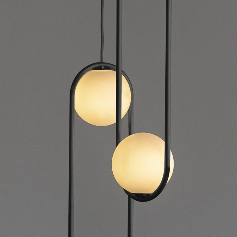 Modern black pendant light with frosted white glass shades and warm LED lighting