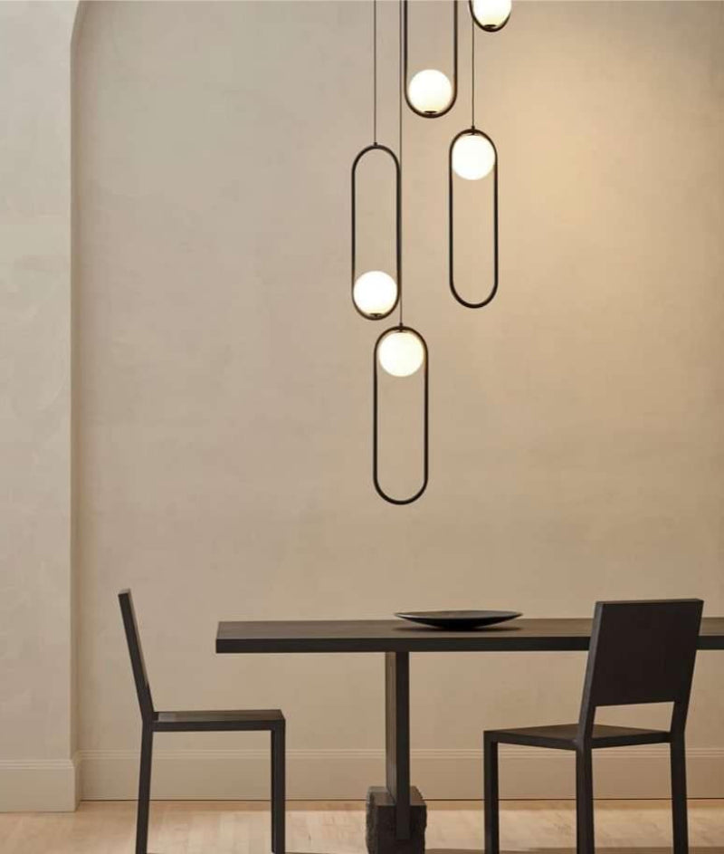 Black 5-light glass globe pendant chandelier creating elegant lighting fixture above dining room table