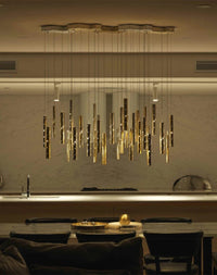 Thumbnail for Modern linear cylinder chandelier in dining room, gold meteor shower design with perforated tubes for kitchen island