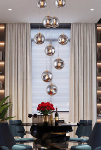 Thumbnail for Modern dining room with a chandelier, table, chairs, and a window with blinds.