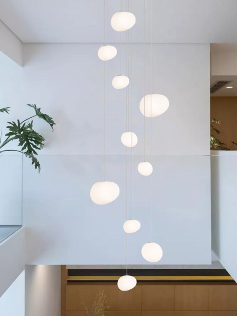 Ethereal stellar pendant illuminating stairway with celestial elegance through white acrylic orbs for foyer entryway