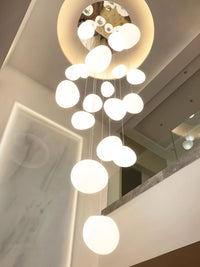 Thumbnail for Dramatic celestial lighting fixture with mixed-size cosmic orbs creating enchanting ambiance for staircase two-story space