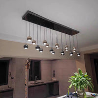 Thumbnail for This handcrafted cognac-colored glass pendant light, featuring truffle-shaped gold sphere accents, is perfect for use above a kitchen island or dining table.