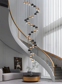 Thumbnail for Contemporary stair chandelier with cognac glass chocolate balls in gold finish for modern foyer entryway two-story ceiling