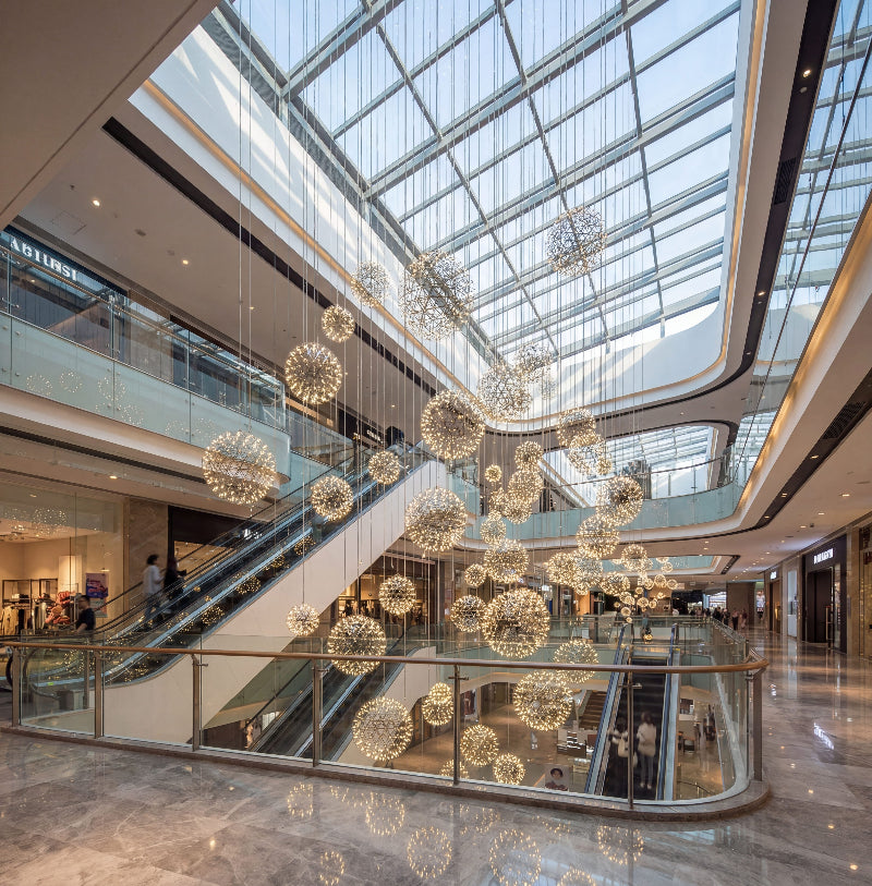 Designer Celestial Burst modern LED firework chandelier with chrome dandelion starburst creating artistic lighting in contemporary high ceiling space