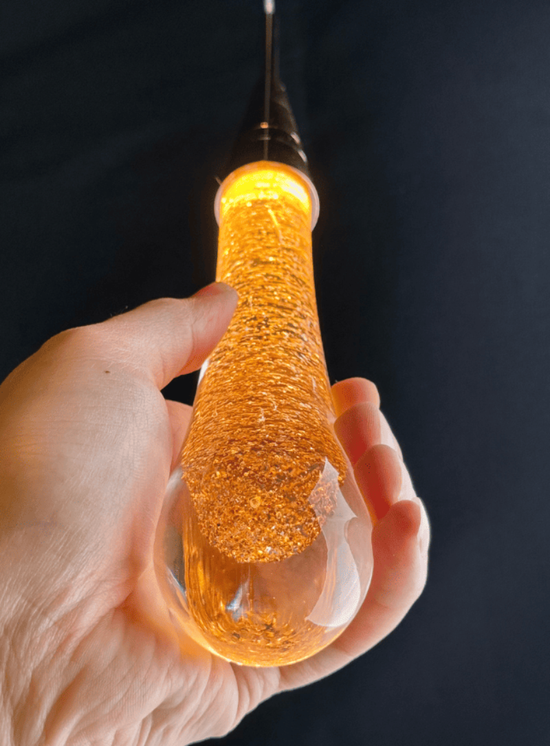 Luxury modern crystal raindrop chandelier, champagne rain with integrated LED for foyer staircase entryway lighting.Close-up of a crystal