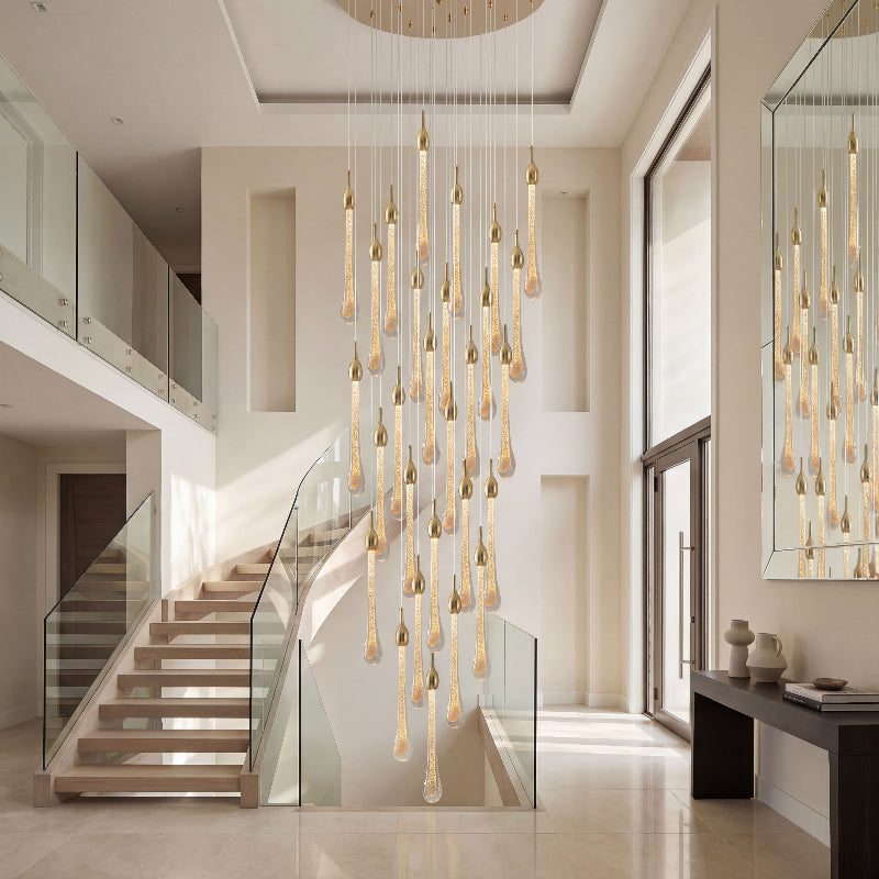 Luxury gold Seraphim Cascade angel tears crystal chandelier with cascading teardrop pendants illuminating elegant two-story staircase foyer