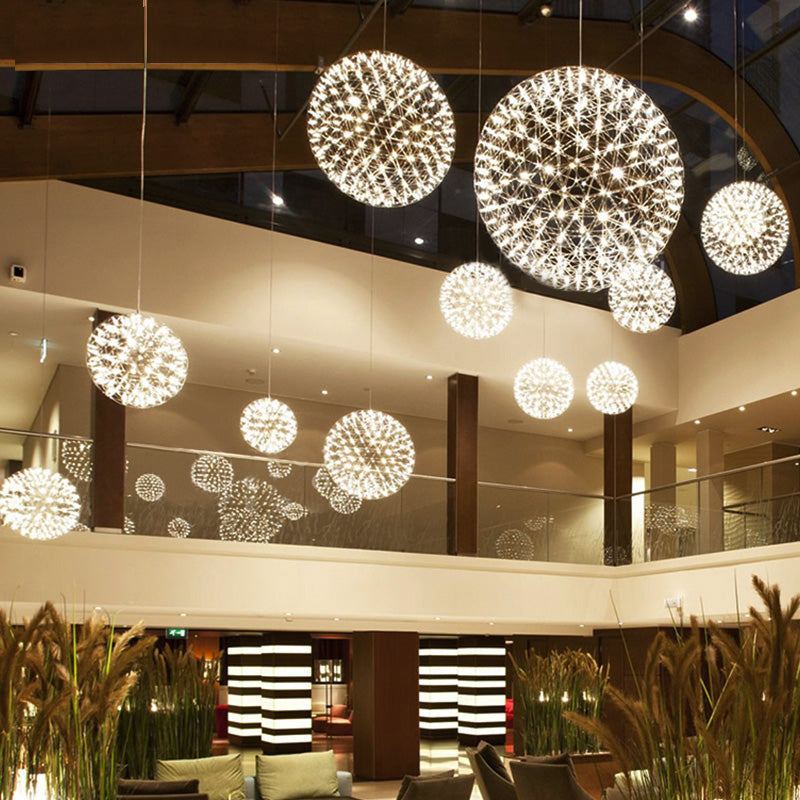 This modern LED firework chandelier for lobbies features a chrome-plated starburst dandelion design, suitable for large spaces with high ceilings such as commercial shopping malls.