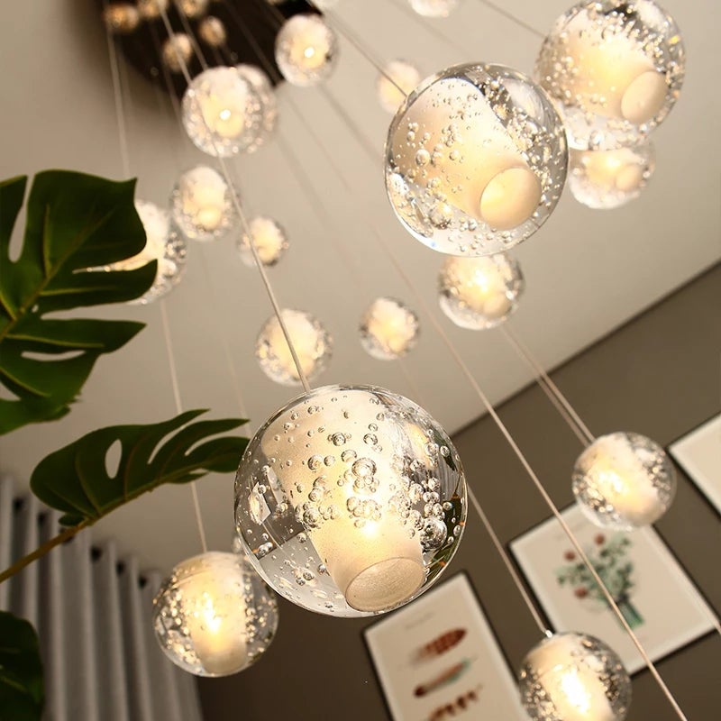 Chrome bubble ball crystal chandelier with dimmable LED floating orbs creating dramatic staircase foyer entryway high ceiling lighting