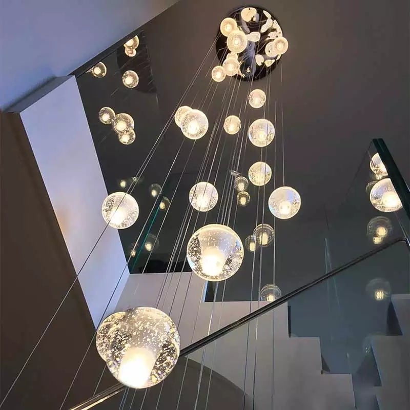 Hanging chrome bubble crystal chandelier with dimmable LED floating orbs creating cascading staircase foyer entryway high ceiling effect