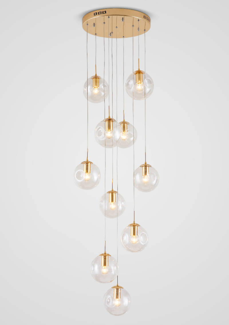 This modern chandelier, featuring transparent Murano-style glass bubbles, creates a striking light refraction effect in the high-ceilinged foyer.