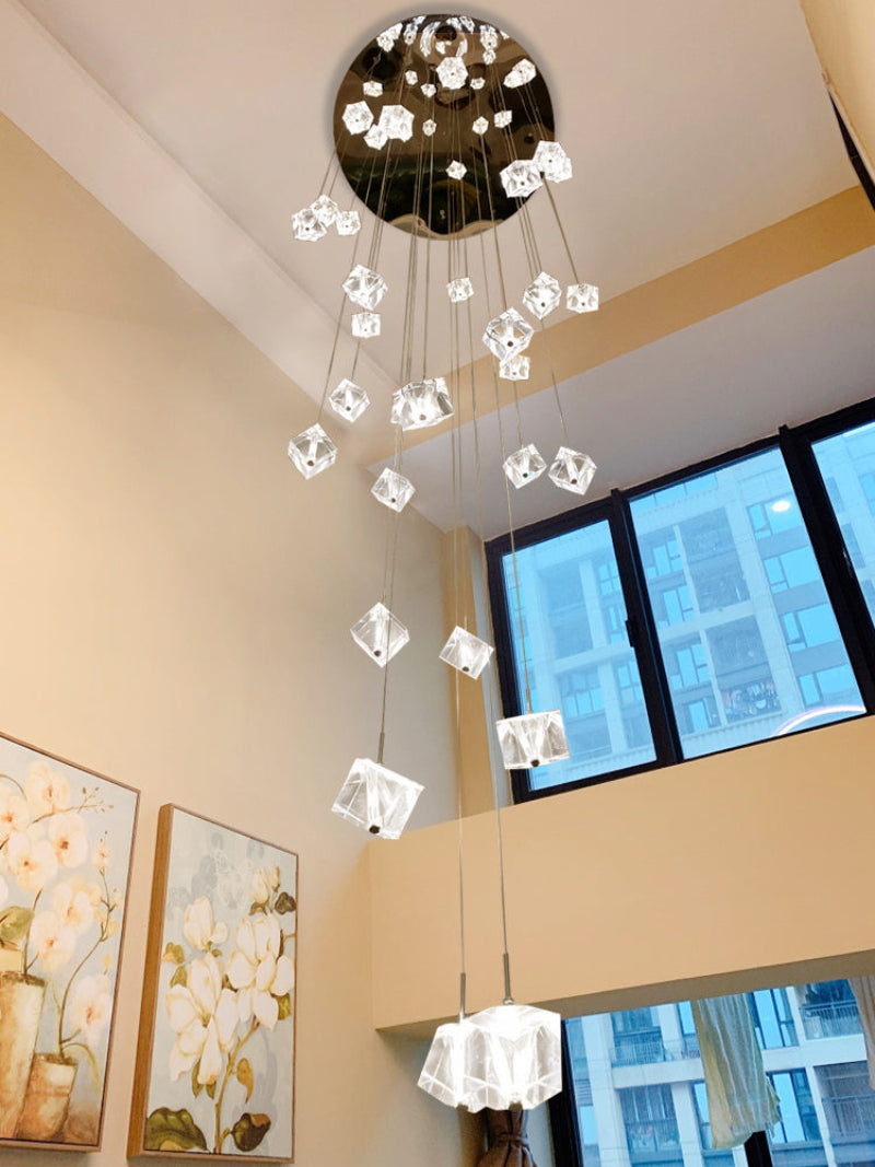 Modern chandelier hanging from a ceiling with a window and artwork in the background