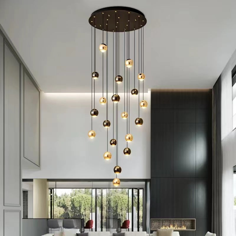 Pendant chandelier with cognac glass chocolate ball design in gold creating moody atmosphere for foyer staircase entryway