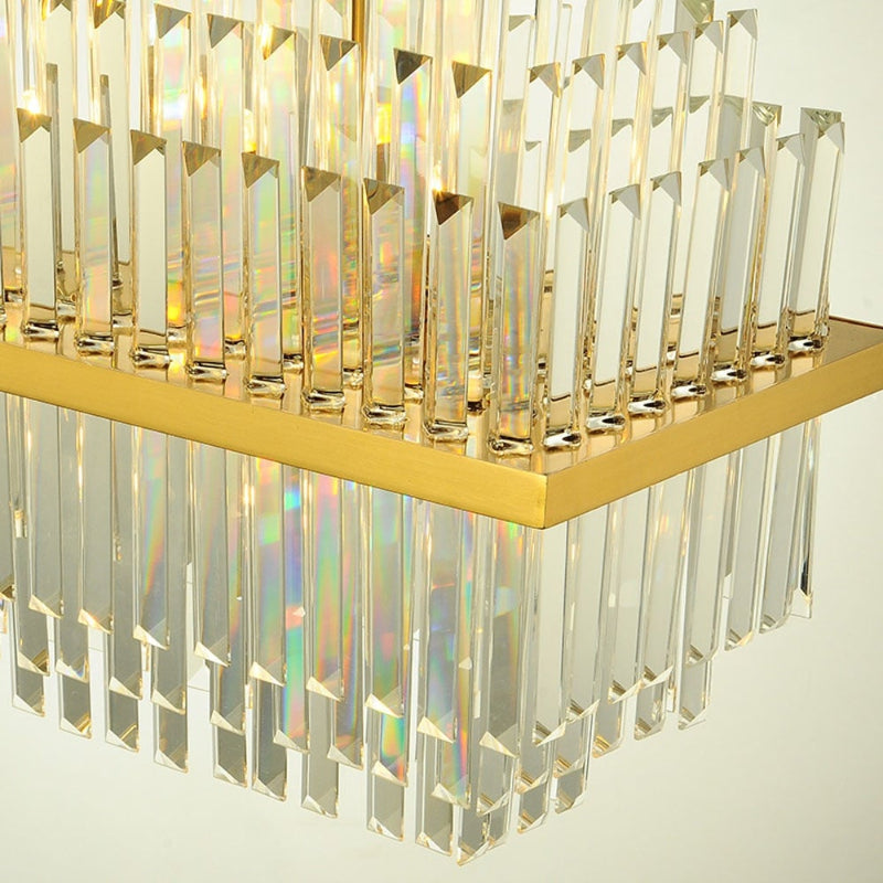 Brushed stainless chandelier with gold finish and tiered crystals creating luxurious ambiance for dining room hotel lobby