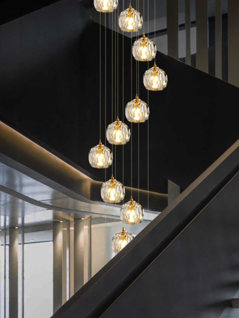 Linear crystal ball chandelier with multi-faceted spheres creating ever-changing glow for staircase foyer entryway two-story space