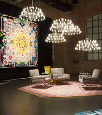 Thumbnail for Modern living room with chandeliers, colorful artwork, and furniture.