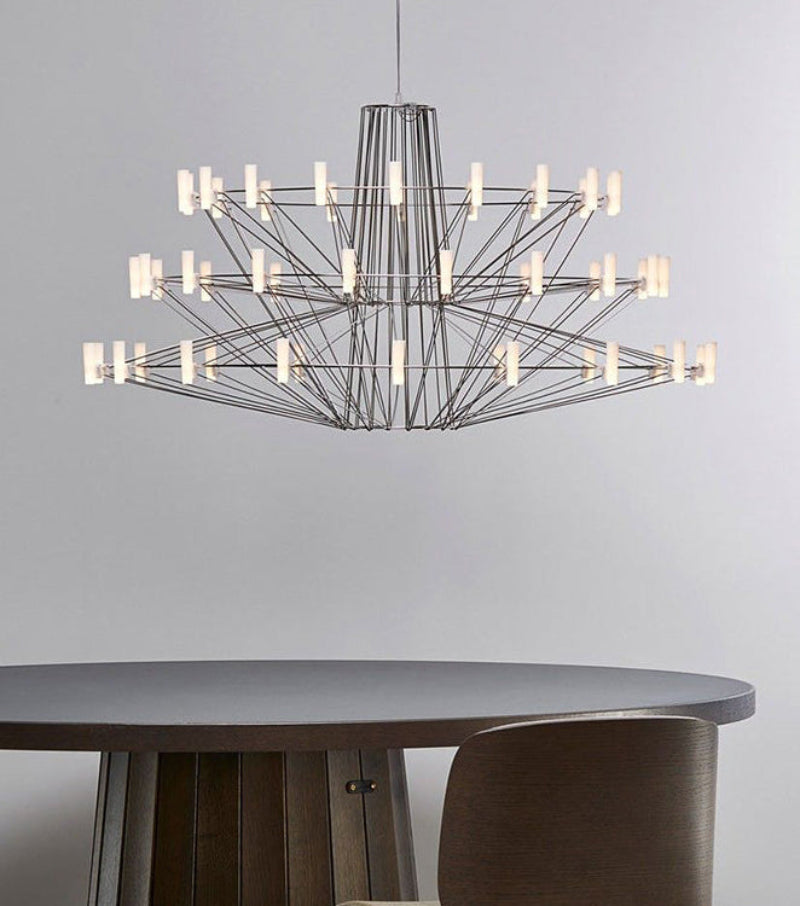 Modern chandelier hanging above a round table with a neutral background