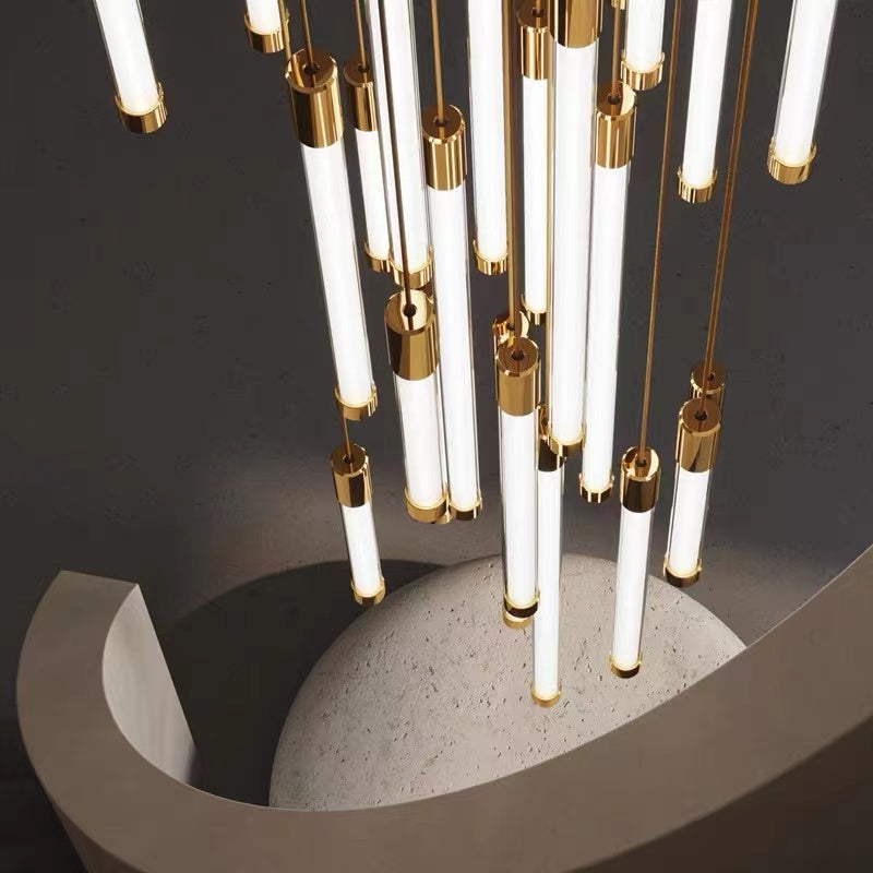 Modern tubular chandelier featuring cascading acrylic tubes in brass finish for contemporary staircase foyer entryway lighting