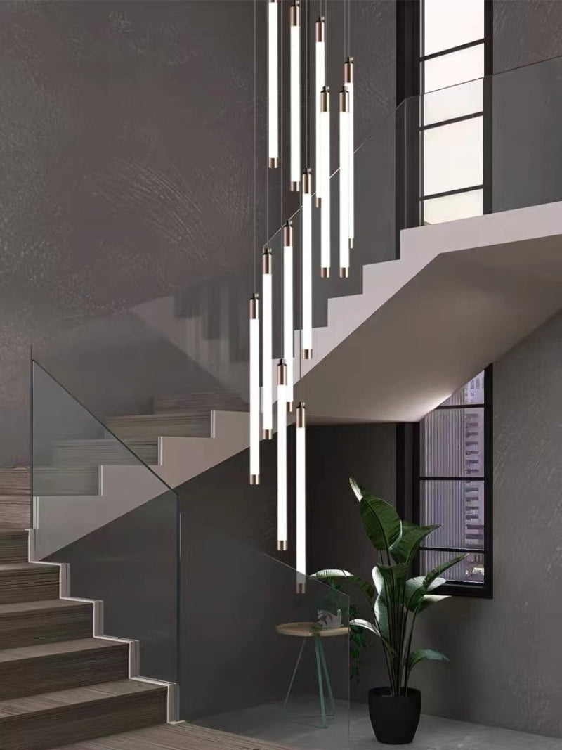 Cascading acrylic chandelier with tubular design creating ethereal luminescence for modern staircase foyer two-story high ceiling