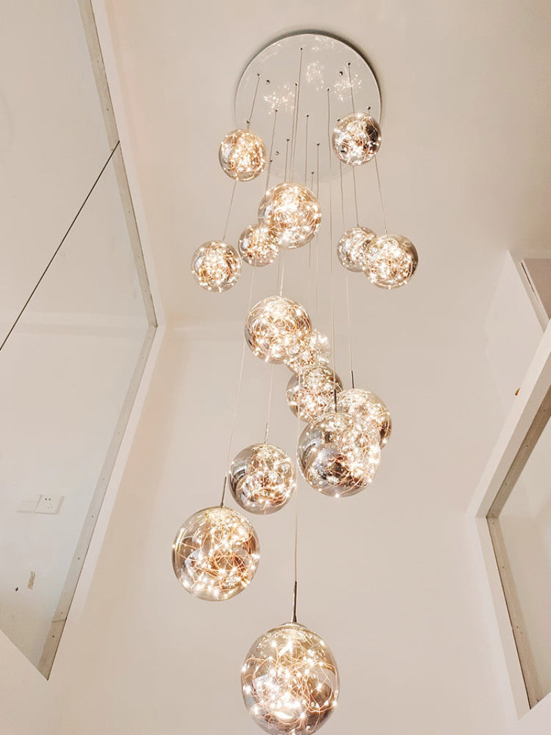 Glass bubble chandelier cluster with firefly-inspired design creating mesmerizing glow for staircase foyer entryway two-story ceiling