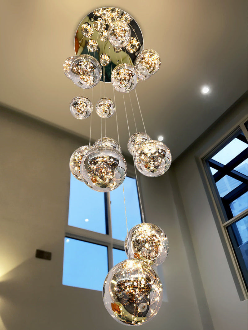 Bubble chandelier light with glass spheres creating firefly-like glow for contemporary staircase foyer entryway two-story space