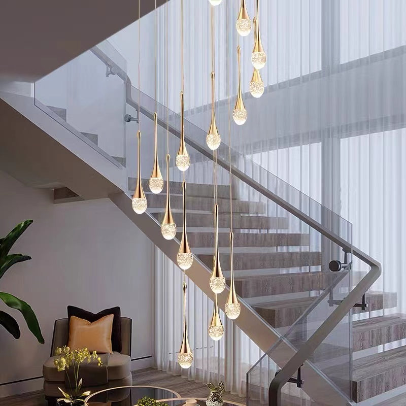 A modern luxury crystal chandelier with a teardrop design featuring golden streamlined light fixture and transparent crystal lampshades, suspended from the ceiling.