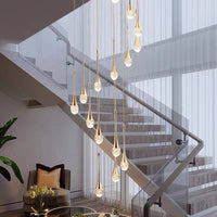 Thumbnail for A modern luxury crystal chandelier with a teardrop design featuring golden streamlined light fixture and transparent crystal lampshades, suspended from the ceiling.