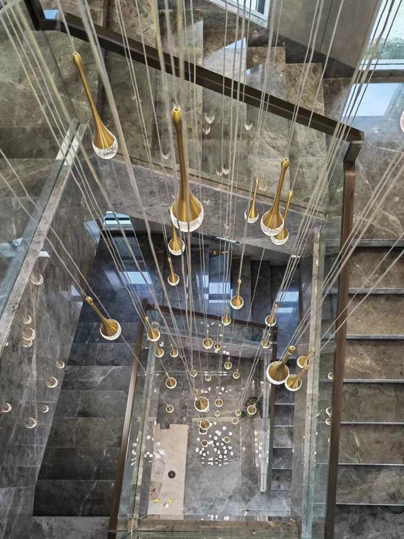 Gold crystal teardrop chandelier with Golden Tears solid crystal bubble effects creating elegant lighting for staircase foyer two-story ceiling