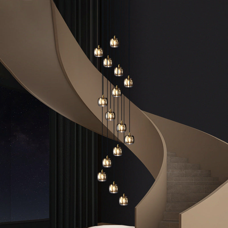 A modern staircase square crystal chandelier with brass fittings hanging in a luxurious interior space, highlighting its elegant design and contemporary style.