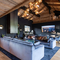 Thumbnail for Modern living room with gray sofa, decorative pillows, and a TV on a dark wall.