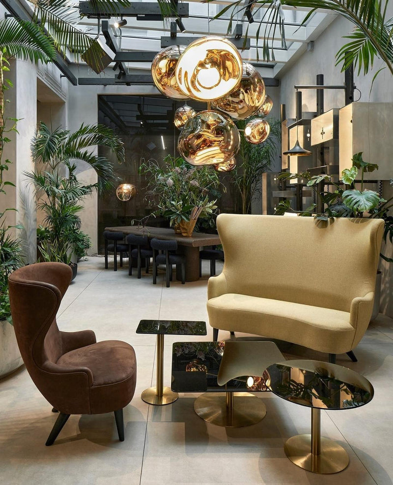 Modern interior design with a beige sofa, brown armchair, and decorative lighting fixture.