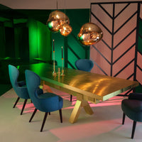 Thumbnail for Modern dining room with a gold table and blue chairs, illuminated by gold pendant lights.