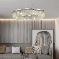 Thumbnail for Modern crystal ring chandelier with LED bulbs, hanging over a living room setting, showcasing a contemporary style with a silver finish.